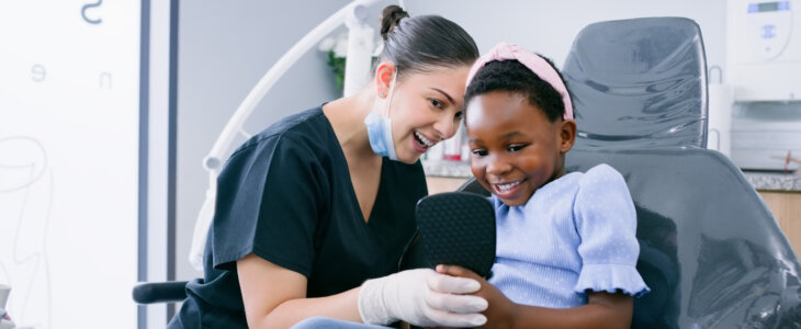 Healthcare, dentist or girl child with mirror for consulting, dental procedure and oral hygiene or happy at hospital. Dentistry, patient or kid with orthodontist for pediatric, gum disease or checkup