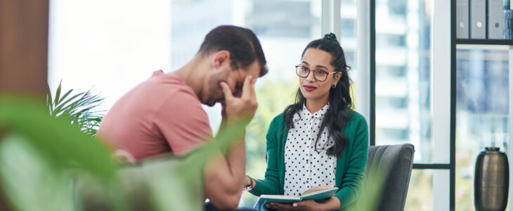 Shot of a young man crying while having a discussion with a woman in a modern office