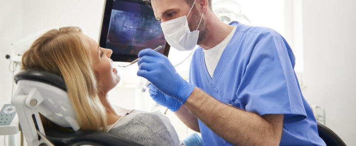 Side view of stomatologist doing his work in dentist's clinic