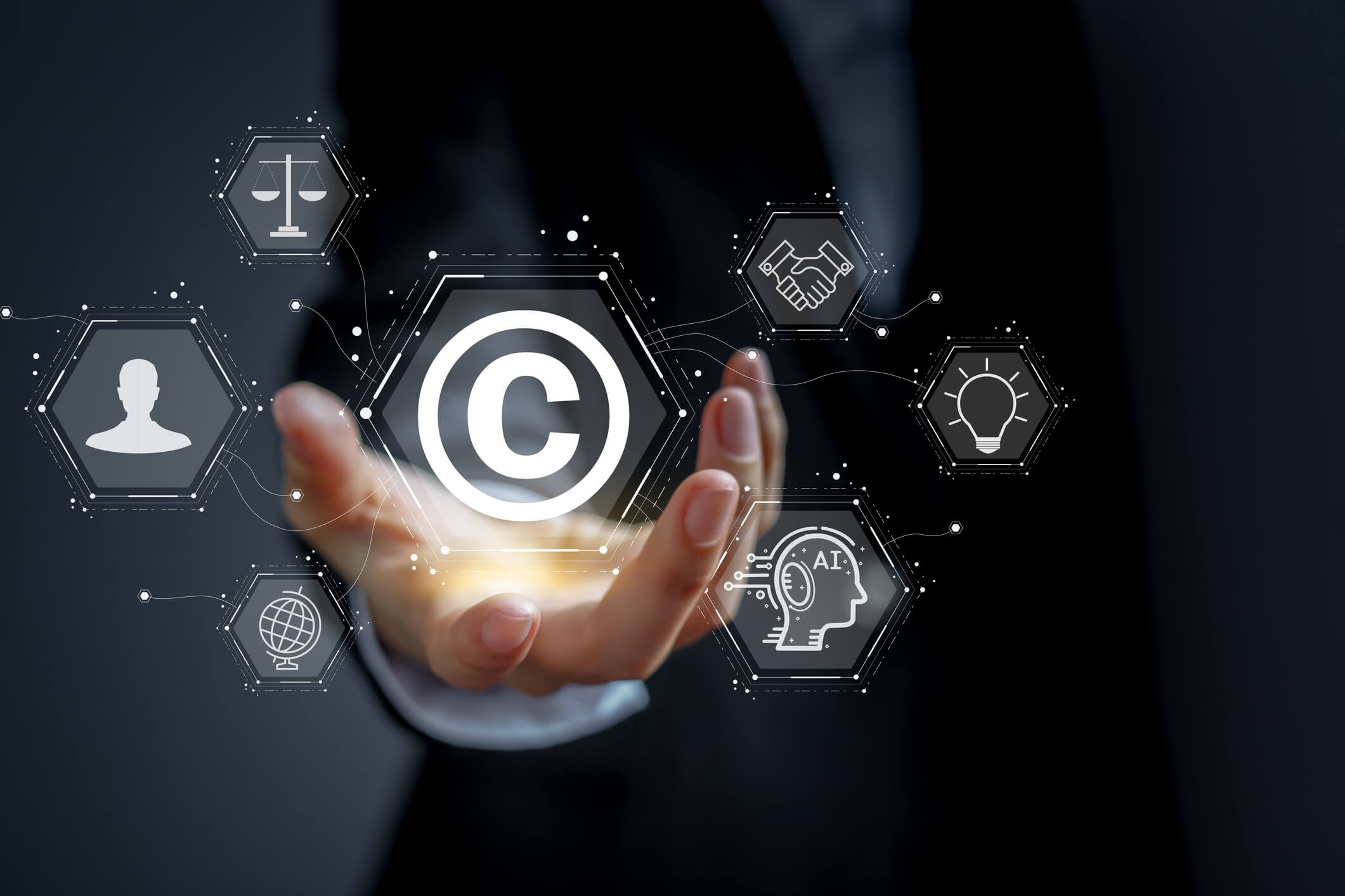 Concept of protecting and protecting against copyright infringement. The hand of a business person is holding a copyright icon.